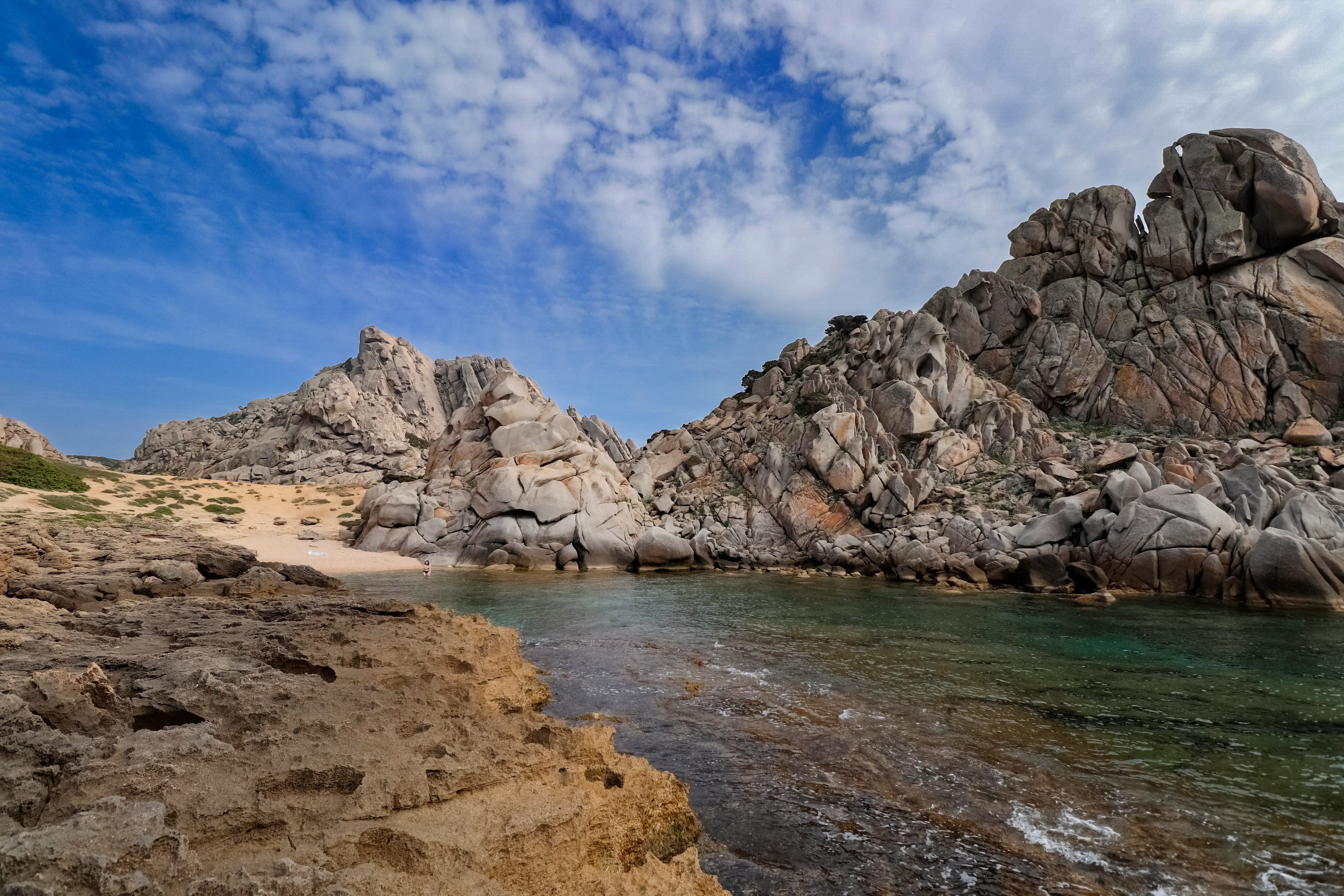a rocky beach with a body of water in front of it